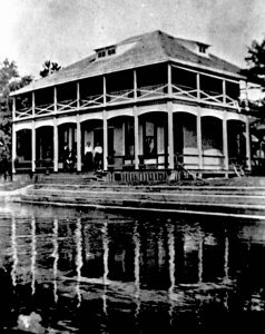 Black and White photo of the Stranahan House with the reflection of the house visible in the water in the foreground